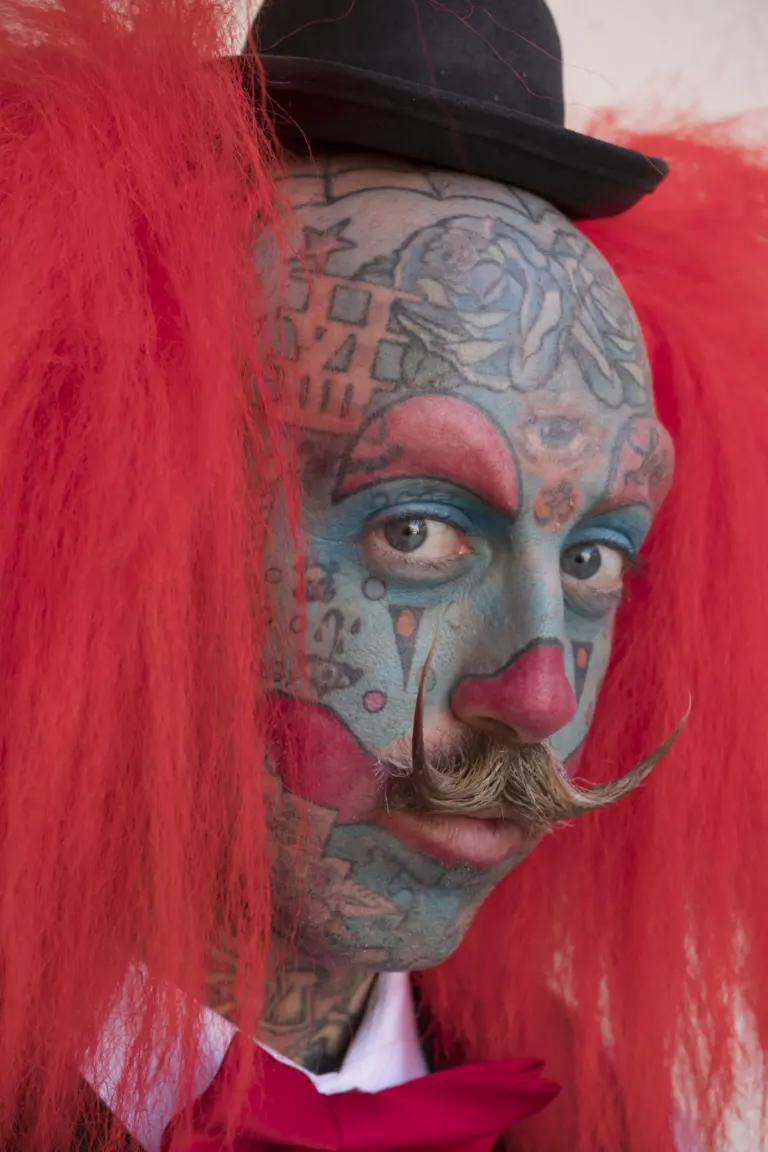 Retrato de hombre con tatuaje facial completo y peluca roja, imagen de portada del proyecto Más allá del límite